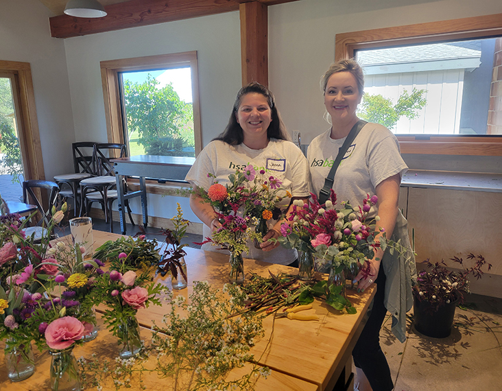 HSA Bank volunteers behind floral arrangements