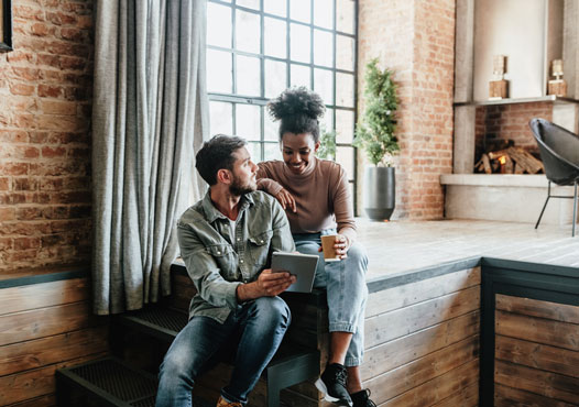 man-drinking-cup-with-child-on-lap-looking-at-laptop